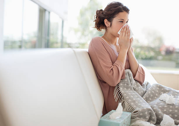 sick mujer soplando su nariz - resfriado y gripe fotografías e imágenes de stock