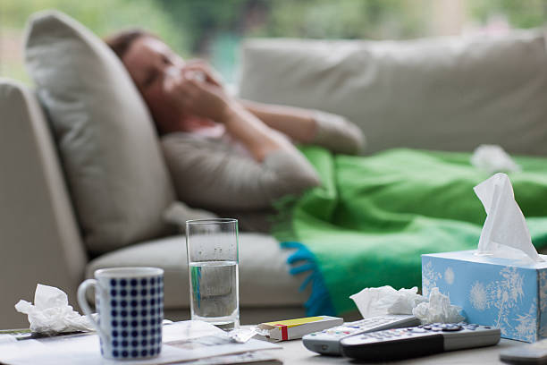 sick woman laying on sofa blowing nose - sjukdom bildbanksfoton och bilder
