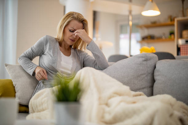 Sick woman lying in bed at home stock photo