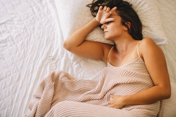 Sick young woman in bed. stock photo