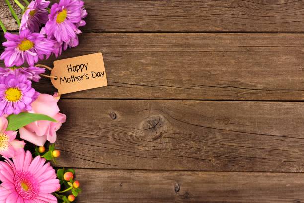 Side border of flowers with Mothers Day gift and tag against rustic wood Side border of flowers with Mothers Day gift tag against a rustic wood background mothers day background stock pictures, royalty-free photos & images