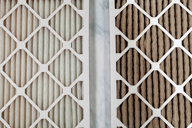 side by side photo of a new unused and old clogged furnace filters stock photo