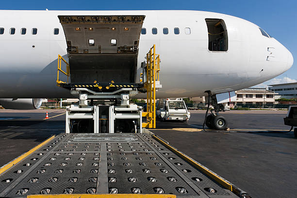 Side cargo hatch of plane open to receive cargo stock photo