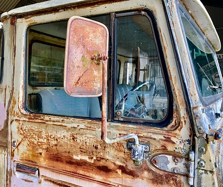 Horizontal country still life of window door side of rustic old pick up rusty ute truck in farm shed on rural country property Australia