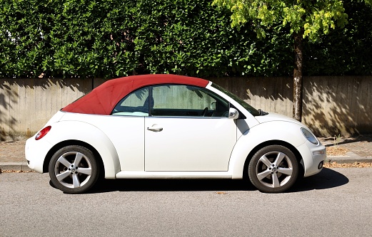 Udine, Italy. July 3, 2022. Side view of convertible Volkswagen Beetle A5 at the roadside. It is the last generation of the  famous old Beetle T1. It' called Coccinelle in France, Fusca in Brasil and Maggiolino in Italy