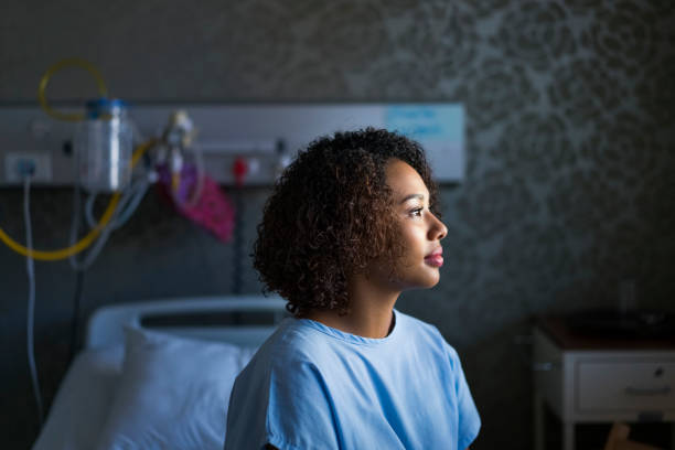 Side view of female patient sitting at hospital stock photo
