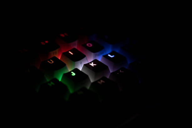 side view of illuminated RGB keycaps keys in the dark stock photo