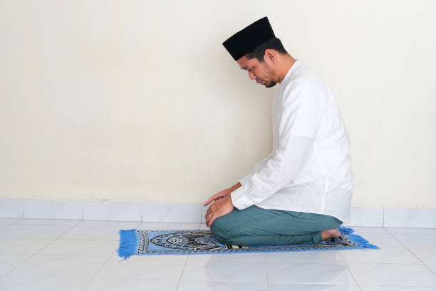 Side view of moslem Asian man praying Side view of moslem Asian man praying Eid ul Fitr 2022 stock pictures, royalty-free photos & images