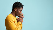 istock Side view of praying african american young man, copy space 1369154265