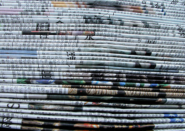 side view of stacks of Asian newspapers stock photo