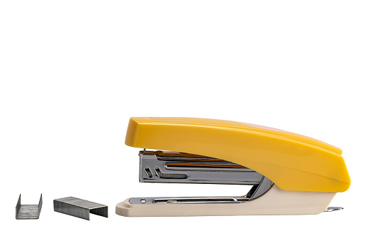 Side view of yellow stapler and row of spare staples isolated on white background with clipping path.