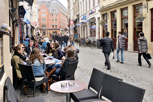 Brussels, Belgium - March 7, 2014: Young Belgian peoples sitting in a street cafe back of the Grand Place in Brussels. 