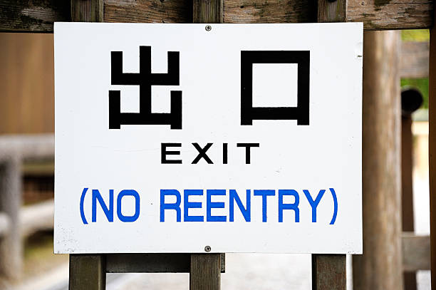 Sign in Japanese and English language Sign in Japanese and English language indicating the spot where the exit is situated. Also in English language the remark that there is no reentry possible reentry stock pictures, royalty-free photos & images