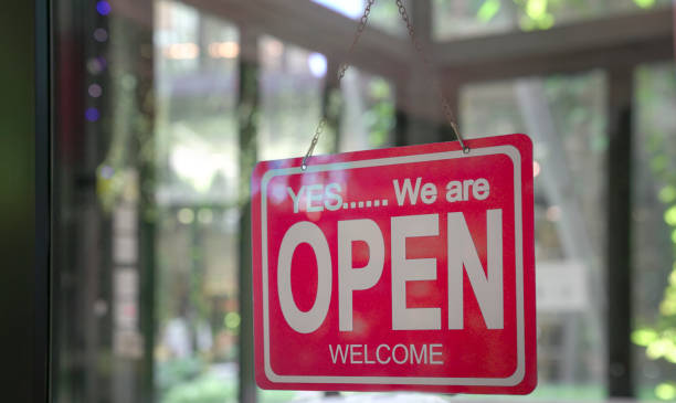 Signboard, Yes We Are Open, hanging on glass door of a restaurant. stock photo