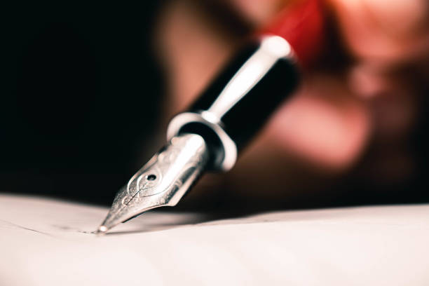 Signing the contract document with fountain pen, close-up shot. stock photo