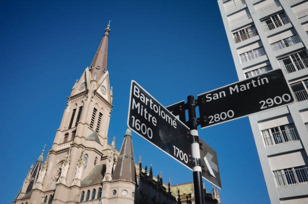 Signpost with street names. Cathedral Church called Basilica Catedral de los Santos Pedro y Cecilia on background. stock photo