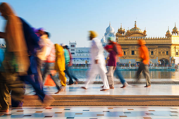 Sikh pilgrims walking past Golden Temple in India Group of Sikh pilgrims walking by the holy pool, Golden Temple, Amritsar, Pun jab state, India, Asia pilgrims monument stock pictures, royalty-free photos & images