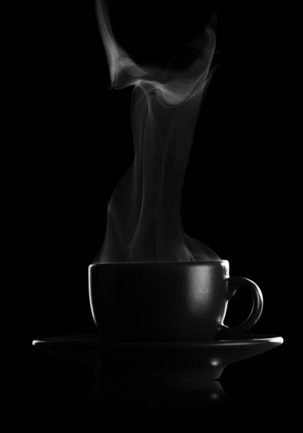 Silhouette coffee cups with saucer and hot steam isolated on black stock photo