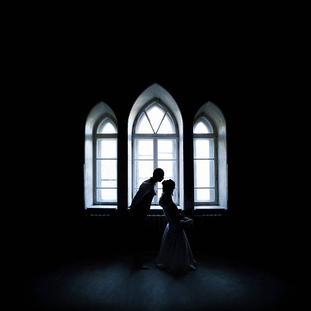 silhouette kissing couple near the vintage window - castle couple stockfoto's en -beelden