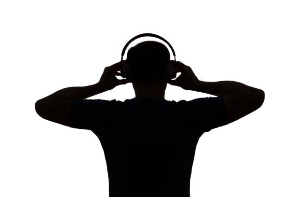 Silhouette of a DJ. He is raising his arms. stock photo