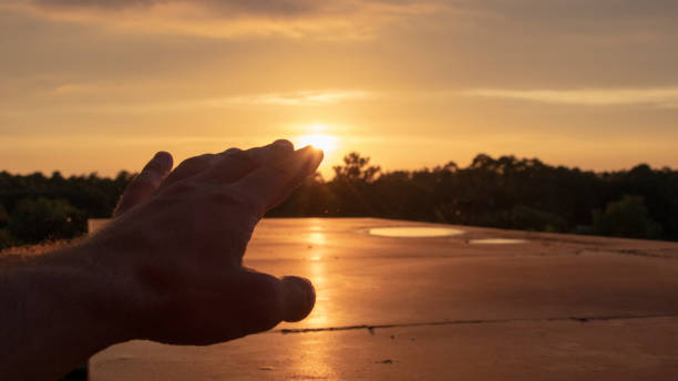 A silhouette of a human hand reaching out stock photo