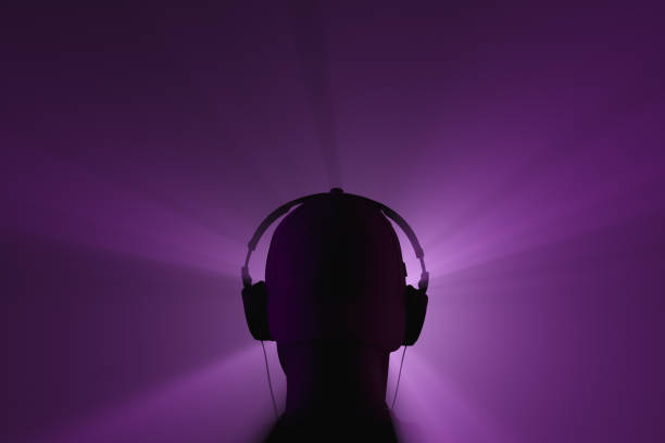 Silhouette of a man in headphones. Back view. Spotlight beams stock photo