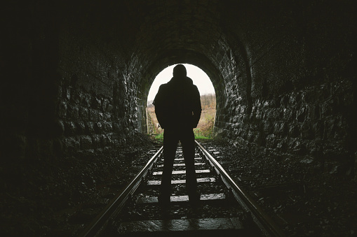 Silhouette Of A Man Walking Down Railroad In Dark Tunnel Stock Photo ... Silhouette Man Walking Tunnel