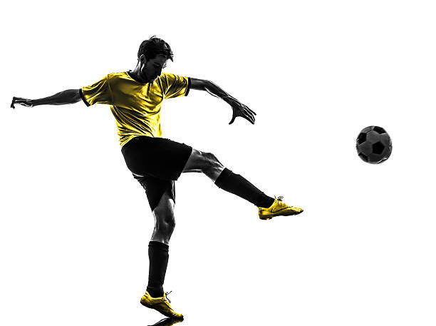 Silhouette of a Young Brazilian soccer player kicking a ball one brazilian soccer football player young man kicking in silhouette studio  on white background kicking stock pictures, royalty-free photos & images