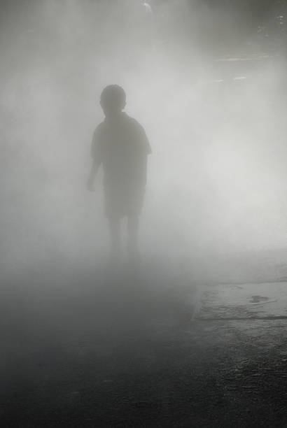 Silhouette of Boy Walking Through Heavy Fog A boy walking through the mist ghost boy stock pictures, royalty-free photos & images