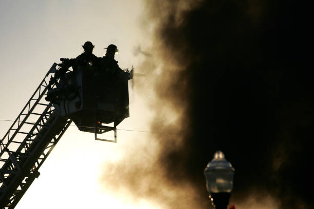 Silhouette of Firemen in a basket lift stock photo