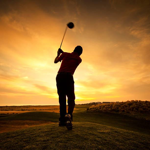 Silhouette of golfer during sunset stock photo
