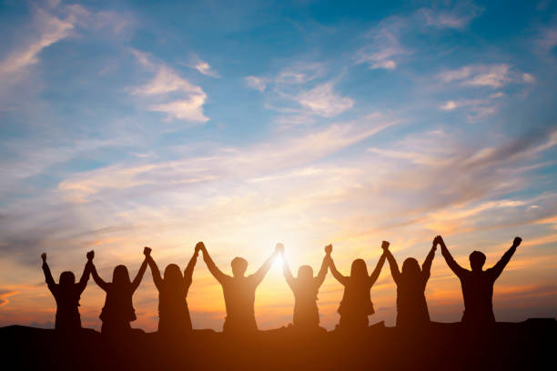 silhouette of happy business team making high hands in sunset sky background for business teamwork concept - her happy place is with her team imagens e fotografias de stock