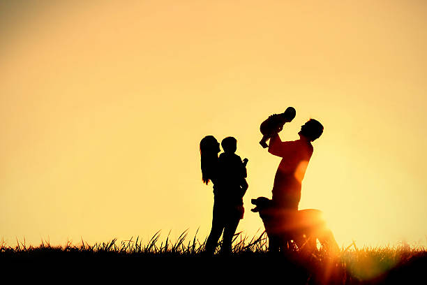 Silhouette of Happy Family and Dog stock photo