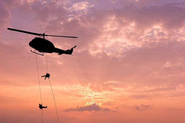 Silhouette of helicopter, soldiers rescue helicopter operations on sunset sky background. Silhouette of helicopter, soldiers rescue helicopter operations on sunset sky background. military helicopter stock pictures, royalty-free photos & images