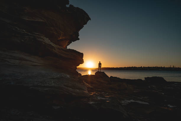 Silhouette of male person standing by dramatic sandstone cliff escarpment during moody sunset Location: Royal National Park, Sydney, Australia
Shot with Nikon D800E golden hour stock pictures, royalty-free photos & images