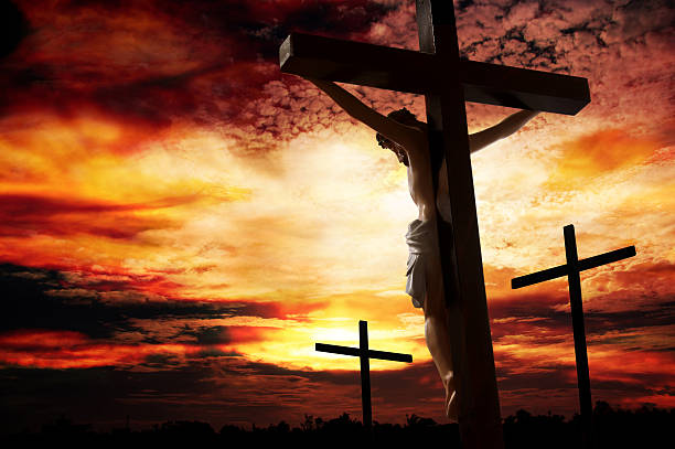 Silhouette of man being crucified against a vivid sunset  good friday stock pictures, royalty-free photos & images