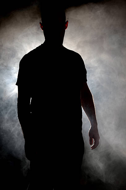 Silhouette of man in a cloud of smoke stock photo