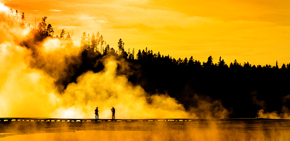 Silhouette of people photographing person steam geysers steam