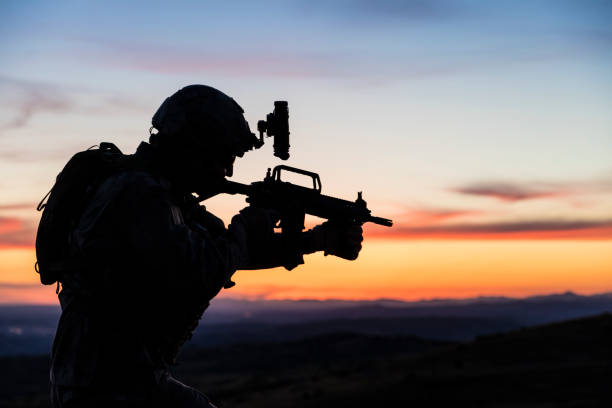 Silhouette of Soldier during military mission at sunset Silhouette of Soldier during military mission at sunset infantry stock pictures, royalty-free photos & images