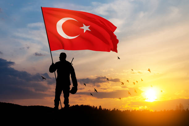 Silhouette of soldier with Turkey flag against the sunrise or sunset. stock photo