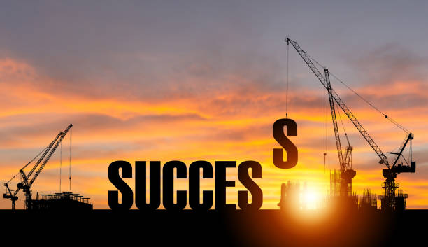 Silhouette of Success on construction site with crane and sunset sky for preparation business concepts stock photo