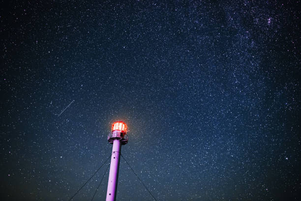 Silhouette of the Lighthouse against the background of the starry sky stock photo