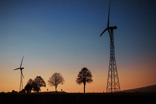 Silhouette of wind turbine during sunset stock photo