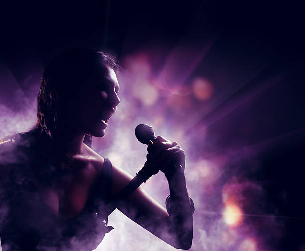 silhouette silhouette of a woman on a background of lights singer stock pictures, royalty-free photos & images
