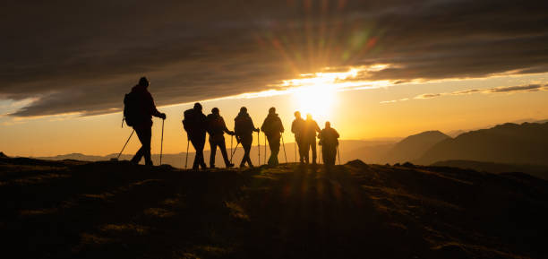 Silhouettes Of Hikers At Sunset stock photo