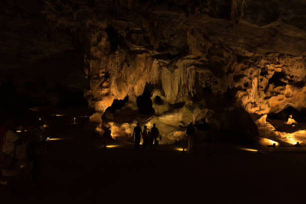 silhouetten van mensen tegen rotsformaties in de grotten van cango - cango stockfoto's en -beelden