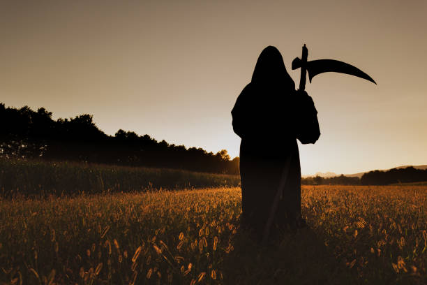 Silhuette of Grim Reaper in the sunset. stock photo