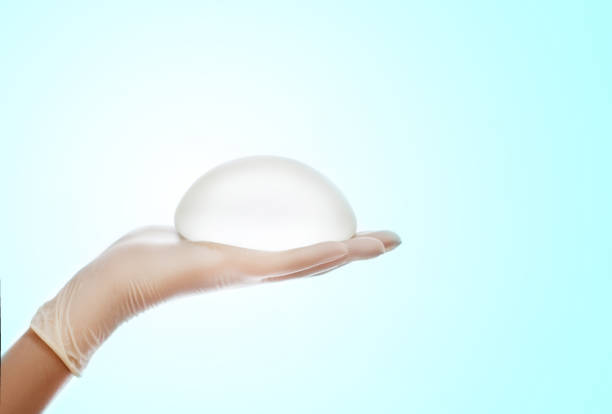 Silicone breast implant on hands stock photo