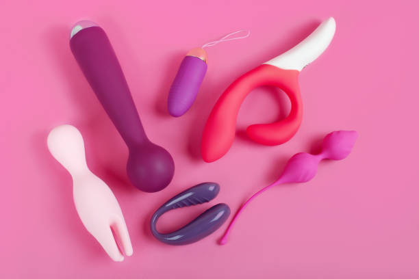 siliconen seksspeeltjes op een roze achtergrond. erotisch speelgoed voor de lol. sex gadget en masturbatie apparaat. - erotische speeltjes stockfoto's en -beelden