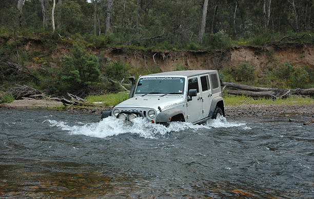 Silver 2007 Jeep JK Wrangler Rubicon river crossing stock photo